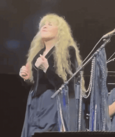 Blonde Woman Singing Into Microphone On Stage GIF