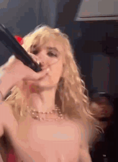 Blonde Woman Singing Into Microphone On Stage GIF
