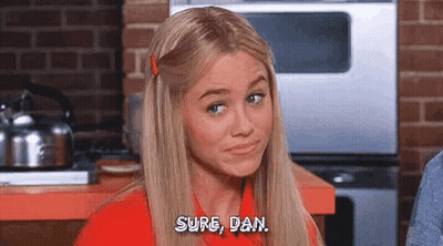 Blonde Woman Sitting In Kitchen Talking GIF