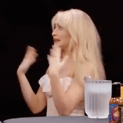 Blonde Woman Sitting With Hot Sauce And Water GIF