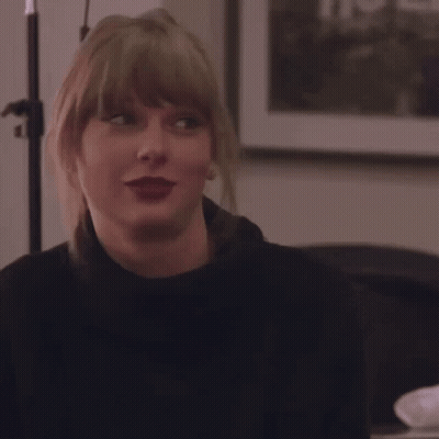 Blonde Woman Smiling In Front Of A Picture GIF