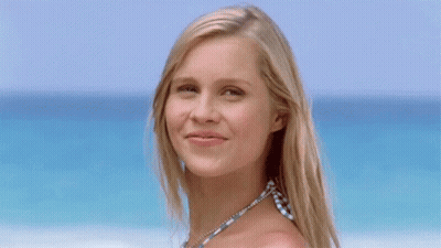 Blonde Woman Waving Hand In Front Of Ocean GIF