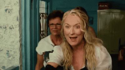 Blonde Woman With Glasses Standing Next To Another Woman GIF