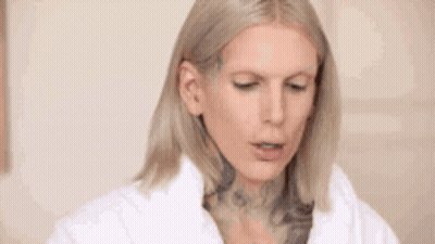 Blonde Woman With Tattoo In White Coat GIF