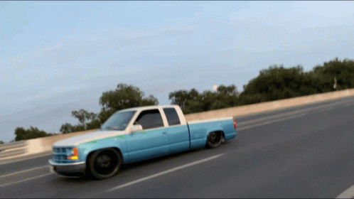 Blue And White Truck Driving Down Road GIF