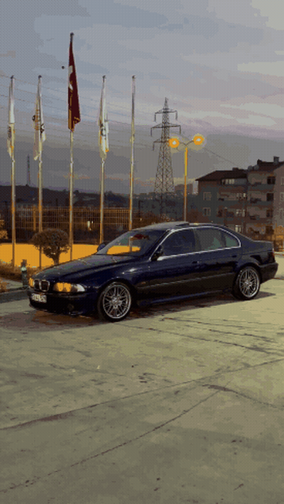 Blue BMW Parked With Flags GIF