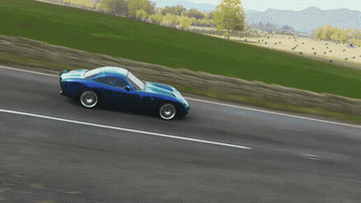 Blue Car Driving Down Road With Grassy Field GIF
