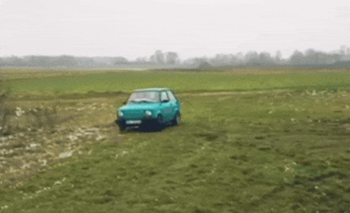 Blue Car Driving Through Grassy Field GIF