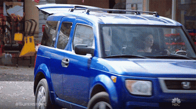 Blue Car Parked In Front Of NBC Store GIF