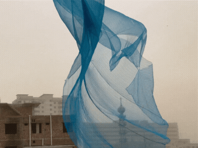 Blue Cloth Blowing in Wind in Front of City