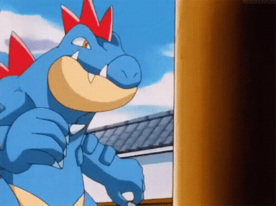 Blue Dinosaur With Red Spikes Next To Building GIF