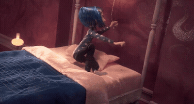Blue-Haired Doll Sitting On Bed GIF