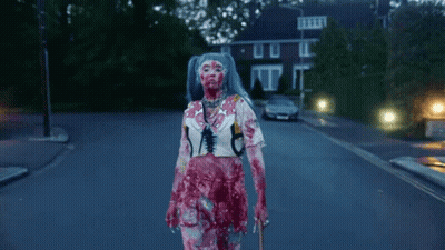 Blue-Haired Woman Covered In Blood Walking Down Street GIF