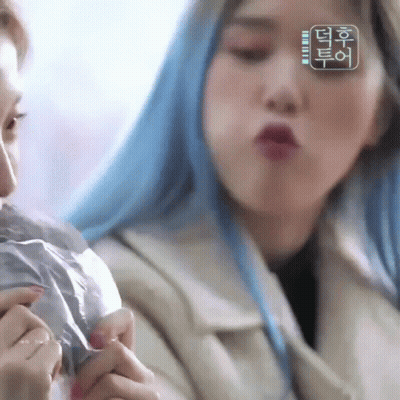 Blue-Haired Woman Making Funny Face Holding Condom GIF