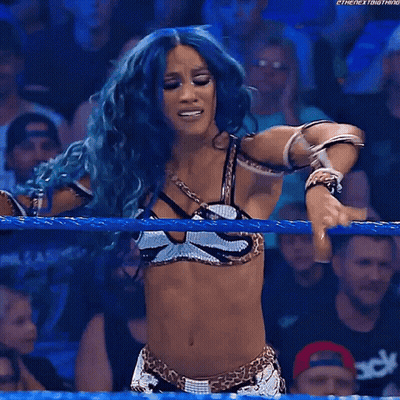 Blue-Haired Woman Raising Hands In Wrestling Ring GIF