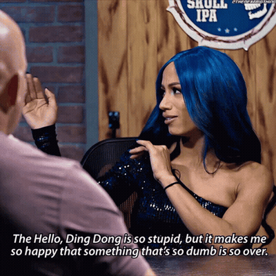 Blue-Haired Woman Talking To Man Near Skull IPA Sign GIF