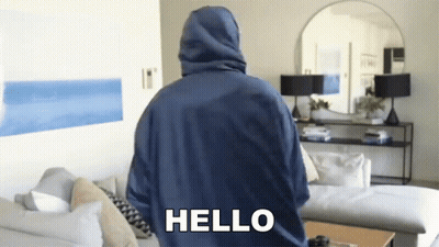 Blue Hoodie Man Standing With Couch And Mirror GIF