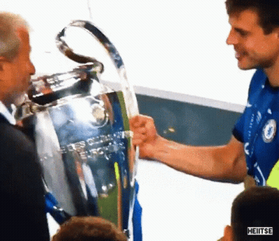 Blue Shirt Man Shaking Hands With Black Shirt Man Holding Trophy GIF