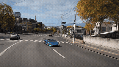 Blue Sports Car Driving Down Road