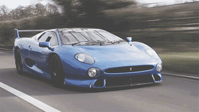 Blue Sports Car Driving Down Road With Trees GIF