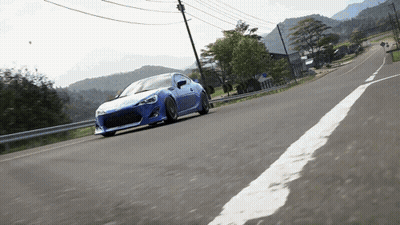 Blue Sports Car Driving Past Mountains GIF