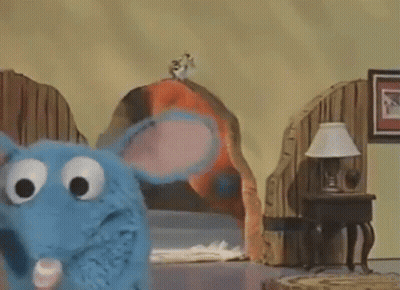 Blue Stuffed Animal Standing Next To Bed And Lamp GIF