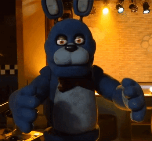 Blue Stuffed Animal With Bow Tie In Dark Room GIF