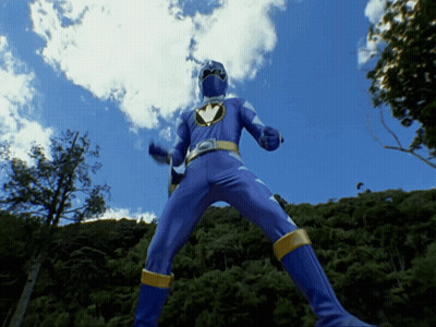 Blue Superhero Standing In Front Of Trees GIF