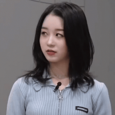 Blue Sweater Woman With Zipper And Necklace Looking At Camera GIF