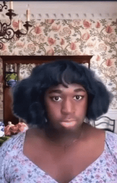 Blue Wig Floral Top Woman Looking At Camera GIF