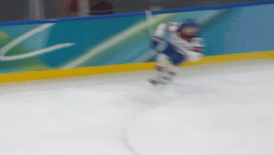 Blurred Hockey Player In Front Of Wall With Letter C GIF