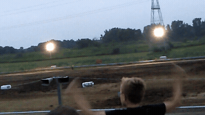 Blurred Person Watching Race With Arms Up GIF