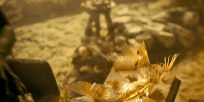 Blurred Pile Of Gold Leaves And Statue GIF