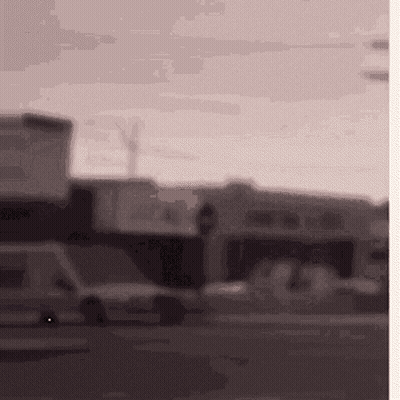 Blurred Street With Sign Saying A GIF