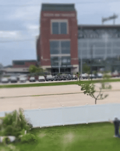 Blurry Brick Building With Parked Cars GIF