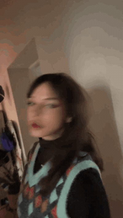 Blurry Girl In Sweater Vest And Glasses GIF