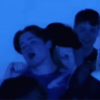 Blurry Group Of People In Blue Room GIF