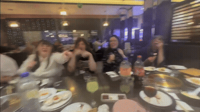 Blurry Group Of People Sitting At Table With Food GIF