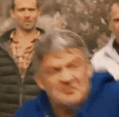 Blurry Group Of People With Woman In Blue Jacket GIF