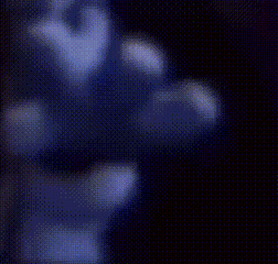 Blurry Hand Holding Remote Control In Dark Room GIF