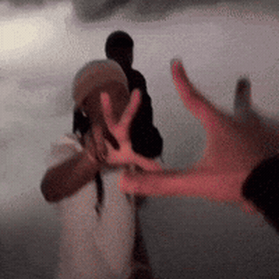 Blurry Hand Reaching Towards Another Person GIF