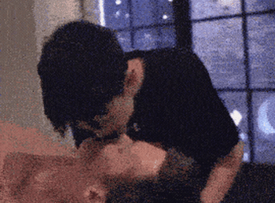 Blurry Man and Woman Kissing in Front of Window