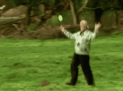 Blurry Man Holding Badminton Racket In Park GIF