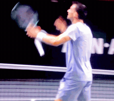 Blurry Man Holding Tennis Racket In Front Of N-A Sign GIF