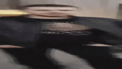 Blurry Man In Black Shirt And Hat Holding Pizza GIF