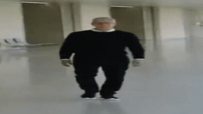 Blurry Man In Black Sweater Walking Down Hallway GIF