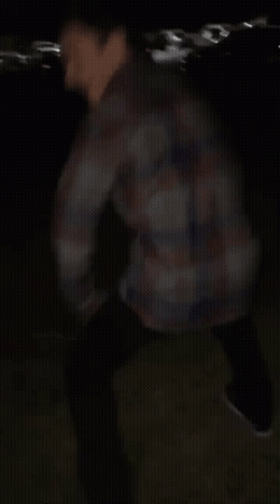 Blurry Man In Plaid Shirt In Dark GIF