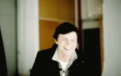 Blurry Man Smiling In Hallway GIF