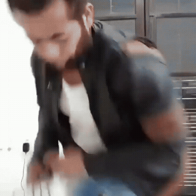 Blurry Man With Ear Buds In Black Jacket GIF