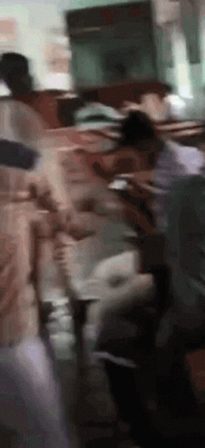 Blurry People Standing Around Table GIF